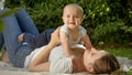 Portrait of happy smiling mother lying on grass and palying with her little baby son. Parenting, family, children Royalty Free Stock Photo