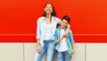 Portrait of happy smiling mother with son teenager on an orange background Royalty Free Stock Photo