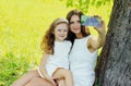 Portrait happy smiling mother taking a selfie by smartphone with her child on the grass in a summer park Royalty Free Stock Photo