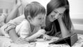 Portrait of happy smiling mother with toddler son browsing video on digital tablet computer in bed Royalty Free Stock Photo