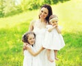 Portrait happy smiling mother with two daughters children on the grass in a summer park Royalty Free Stock Photo