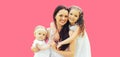 Portrait of happy smiling mother with two daughters children on pink background