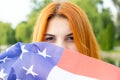 Portrait of happy smiling red haired girl hiding her face behind USA national flag Royalty Free Stock Photo