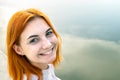 Portrait of happy smiling red haired girl. Positive young woman looking in camera outdoors Royalty Free Stock Photo