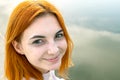 Portrait of happy smiling red haired girl. Positive young woman looking in camera outdoors Royalty Free Stock Photo