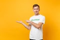 Portrait of happy smiling satisfied young man in white t-shirt with written inscription green title volunteer isolated Royalty Free Stock Photo