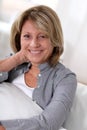 Portrait of happy smiling senior woman sitting on sofa Royalty Free Stock Photo