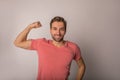 Portrait of a happy smiling strong men in casual t-shirt shows biceps on the arm Royalty Free Stock Photo