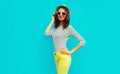 Portrait happy smiling stylish young woman posing wearing a striped t-shirt and summer straw round hat on blue background Royalty Free Stock Photo