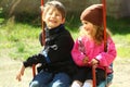 Portrait of happy smiling sunlit children on a swing