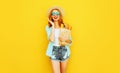 portrait happy smiling surprised woman holding paper bag with long white bread baguette, wearing straw hat, shorts on colorful Royalty Free Stock Photo