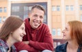 Portrait of happy smiling teenage boy chatting with girls while studying outdoors near university Royalty Free Stock Photo