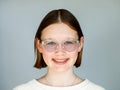 Portrait of a happy smiling teenage girl with dental braces and glasses on white background looking straight into camera