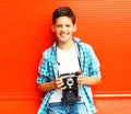 Portrait happy smiling teenager boy with retro camera on a red Royalty Free Stock Photo