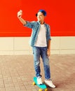 Portrait of happy smiling teenager boy taking selfie by smartphone on red background Royalty Free Stock Photo