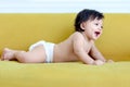 Portrait of happy smiling toddle baby kid lying on yellow sofa in living room at home, little girl daughter spending time at home Royalty Free Stock Photo