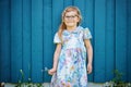 Portrait of happy smiling toddler girl in blue clothes outdoors. Little child with blond hairs looking and smiling at Royalty Free Stock Photo