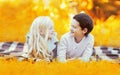 Portrait of happy smiling two children, boy and girl lying together on the grass and looking at each other in sunny autumn park Royalty Free Stock Photo