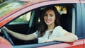 Portrait of happy smiling woman driver behind wheel red car Royalty Free Stock Photo