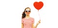 Portrait of happy smiling woman with red heart shaped balloon wearing sunglasses isolated on white background Royalty Free Stock Photo