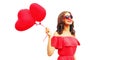 Portrait of happy smiling woman with red heart shaped balloon wearing sunglasses isolated on white background Royalty Free Stock Photo