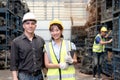 Portrait of happy smiling woman worker with safety vest and helmet holding tablet standing together with industrial senior foreman Royalty Free Stock Photo