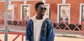 Portrait of happy smiling young african man with backpack looking away on city street background Royalty Free Stock Photo