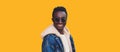 Portrait of happy smiling young african man looking at camera wearing jeans jacket isolated on yellow background Royalty Free Stock Photo