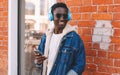 Portrait happy smiling young african man with smartphone listening to music on city street Royalty Free Stock Photo