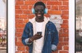 Portrait happy smiling young african man with smartphone listening to music on city street Royalty Free Stock Photo