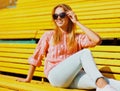 Portrait happy smiling young blonde woman sitting on bench in a city park Royalty Free Stock Photo