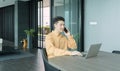 Portrait of happy smiling young business Asian, Chinese man person using laptop computer, working, and talking on smart mobile Royalty Free Stock Photo