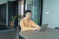 Portrait of happy smiling young business Asian, Chinese man person using laptop notebook computer, working online in meeting room Royalty Free Stock Photo