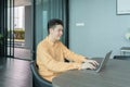 Portrait of happy smiling young business Asian, Chinese man person using laptop notebook computer, working online in meeting room Royalty Free Stock Photo