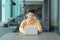 Portrait of happy smiling young business Asian, Chinese man person using laptop notebook computer, working online in meeting room Royalty Free Stock Photo