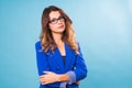 Portrait of happy smiling young cheerful businesswoman in glasses over blue background. Caucasian brunette model in Royalty Free Stock Photo