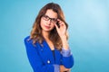 Portrait of happy smiling young cheerful businesswoman in glasses over blue background. Caucasian brunette model in Royalty Free Stock Photo