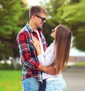 Portrait of happy smiling young couple hugging and looking at each other in summer city park Royalty Free Stock Photo