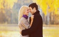 Portrait happy smiling young couple in love in sunny park on yellow leaves background Royalty Free Stock Photo