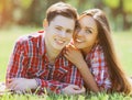 Portrait of happy smiling young couple lying on the grass together in sunny park Royalty Free Stock Photo