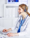 Portrait of a happy smiling young doctor in headset in office