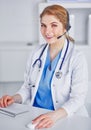 Portrait of a happy smiling young doctor in headset in office