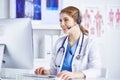 Portrait of a happy smiling young doctor in headset in office