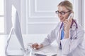 Portrait of a happy smiling young doctor in headset in office