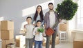 Portrait of happy smiling young family standing in their new house on moving day Royalty Free Stock Photo