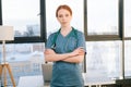 Portrait of happy smiling young female doctor wearing blue green uniform and stethoscope looking at camera. Royalty Free Stock Photo