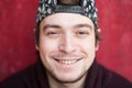 Portrait of happy smiling young man in a baseball cap and sweater on a red background Royalty Free Stock Photo