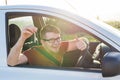 Portrait of happy smiling young man, buyer sitting in his new car and showing keys outside dealer office. Personal Royalty Free Stock Photo