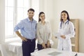 Portrait of happy smiling young married couple together with their family doctor Royalty Free Stock Photo