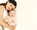 Portrait of happy smiling young mother and cute baby lying on the bed at home together, top view, blank copy space for advertising Royalty Free Stock Photo